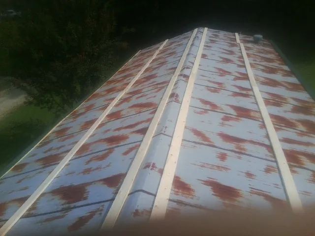 Rusted metal roof panels with new wood purlins before replacement — Storm Damage Roof Repair in Cat Spring by Roofing Brothers