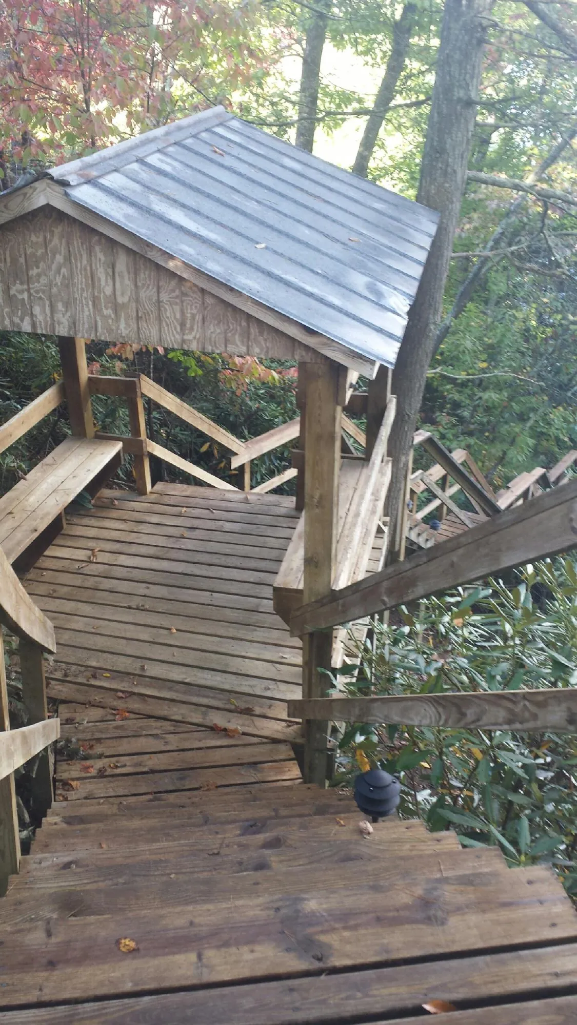 Metal roofed shelter over wooden steps on a wooded walkway — Skylight Repair & Installation work by our crew in Cat Spring